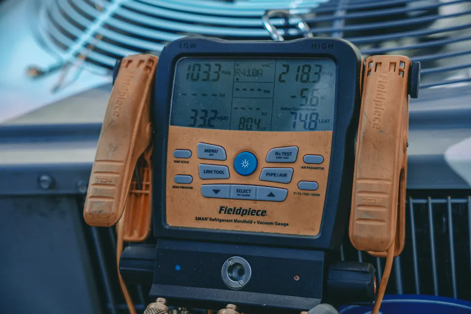 Einstein technician checking AC refrigerant pressure